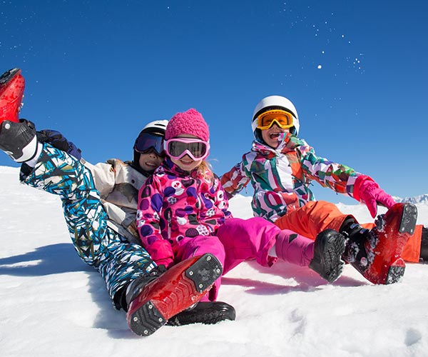 Children sitting on ski slope