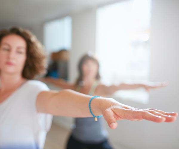 Ladies stretching their arms out in yoga class